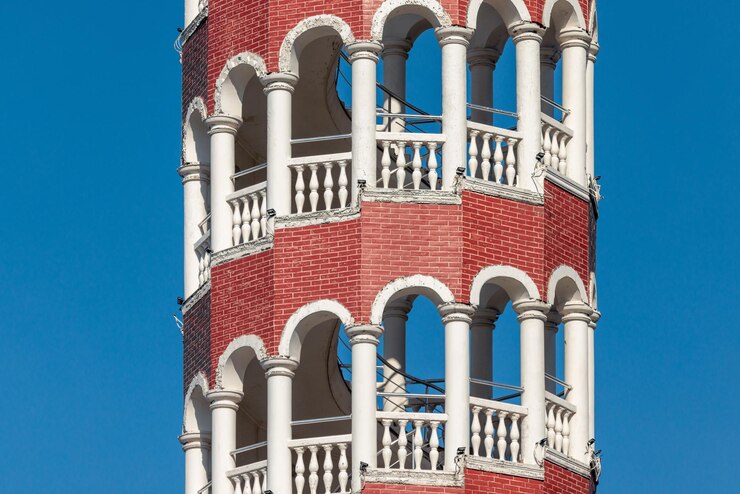 Foto um fragmento de uma alta torre feita de tijolos vermelhos e colunas brancas