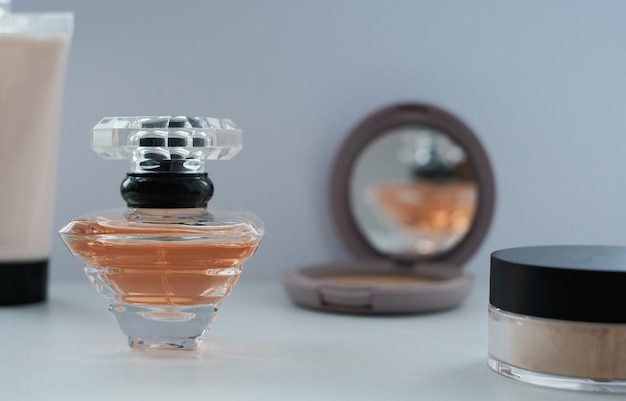 Foto um frasco de perfume cercado por loção em pó de produtos de beleza