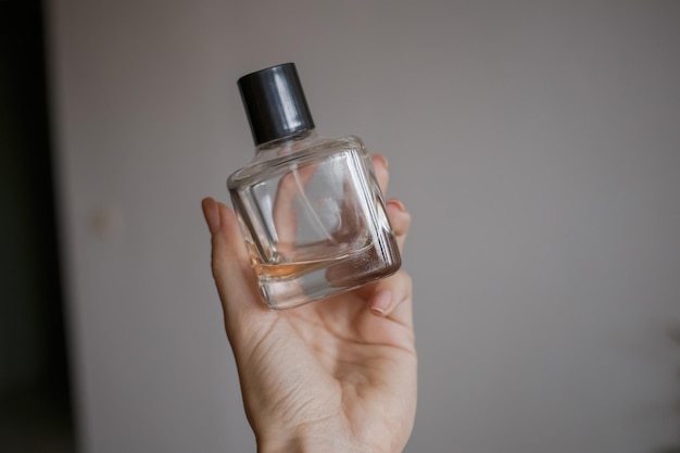 Um frasco de perfume nas mãos de uma garota