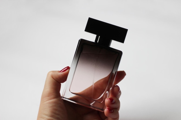 Um frasco de perfume preto em close em um fundo branco isolado Belo perfume para presente