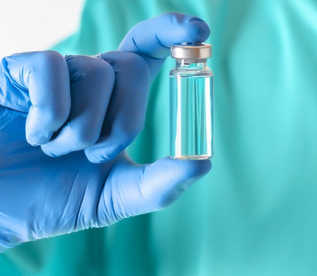 Um frasco de vacina para injeção na mão do médico