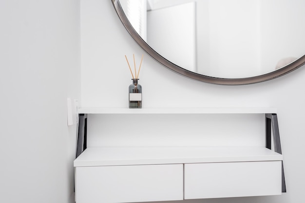 Um frasco de vidro de aroma no interior de um quarto branco