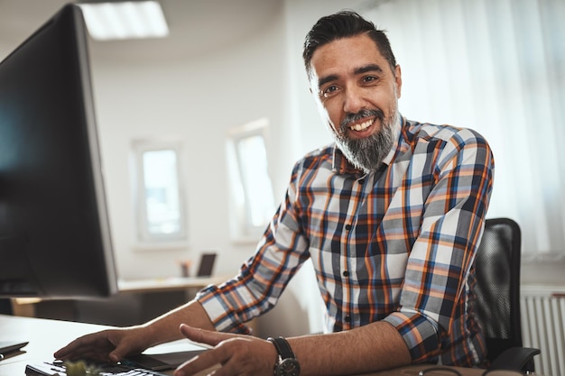 Um freelance sorridente bem-sucedido está trabalhando em um novo projeto no escritório.