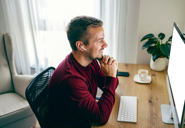 Um freelancer está tendo uma reunião de negócios on-line com seu empregador e trabalhando em casa