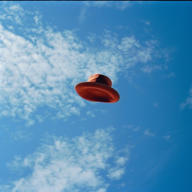 Foto um frisbee vermelho voando pelo céu com o sol brilhando através das nuvens