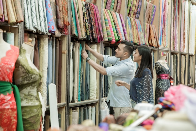 Um funcionário da loja de roupas atende seus clientes