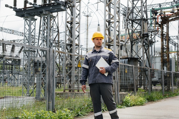 Um funcionário de engenharia faz um tour e inspeciona as modernas subestações elétricas.