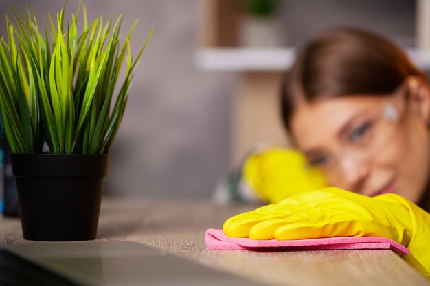 Um funcionário de uma empresa de limpeza limpa o escritório e cuida das plantas