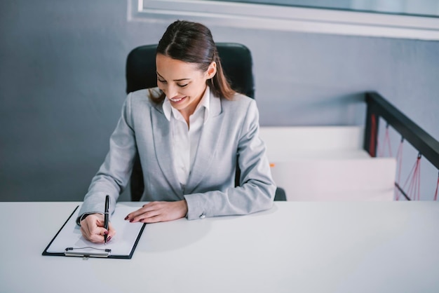 Um funcionário feliz assinando contrato com empresa corporativa no escritório moderno