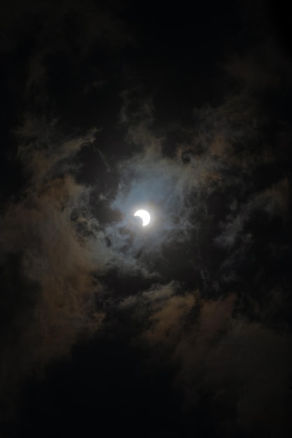 Um fundo de paisagem escura de céu nublado com eclipse solar no centro