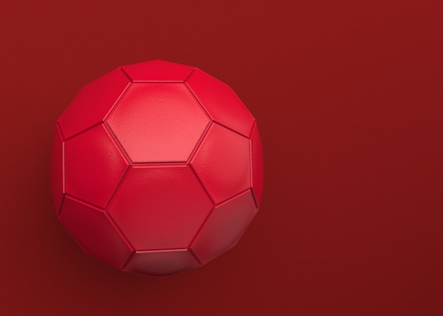 Um futebol de couro vermelho no fundo da obscuridade do espaço da cópia.