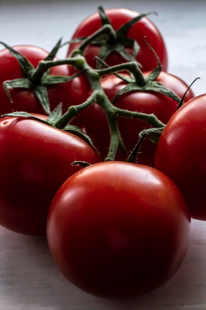 Um galho com suculentos tomates vermelhos brilhantes maduros