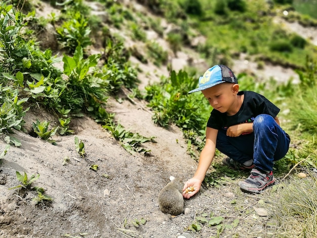 Um garotinho alimenta gopher no desfiladeiro de jilysu kabardinobalkaria rússia junho de 2021