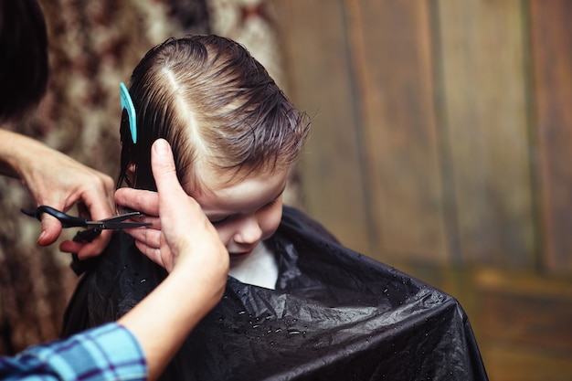 Um garotinho é afetado pelas emoções brilhantes do cabeleireiro em seu rosto