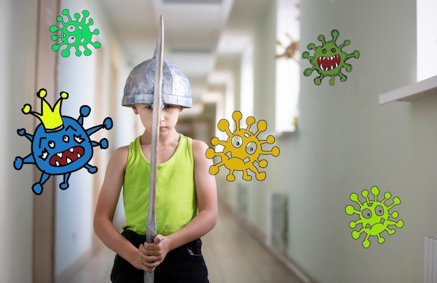 Um garotinho fica em casa com uma espada para se proteger contra o vírus coronavírus covid19