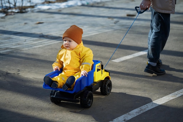 Um garotinho monta um grande caminhão de brinquedo