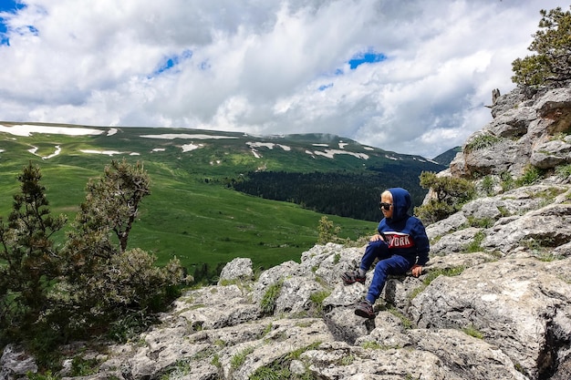 Um garotinho no fundo dos prados alpinos do planalto LagoNaki na Adygea Rússia 2021