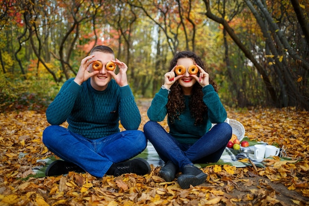 Um garoto e uma garota na floresta de outono com biscoitos