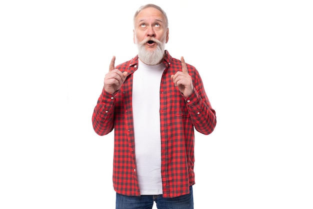 Um gênio bonito, uns sessenta anos, um homem idoso com uma barba cinzenta numa camisa tem uma ideia.