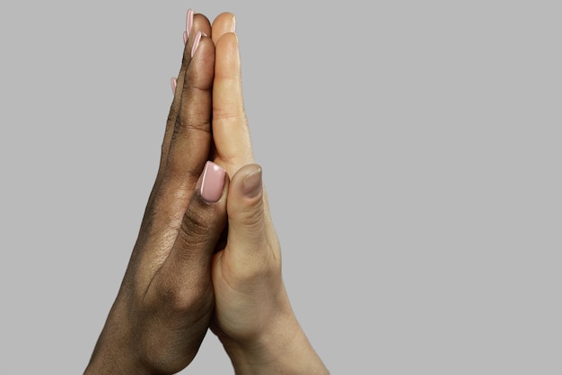 Foto um gesto de cinco altos entre mulheres africanas e caucasianas closeup de palmas em fundo cinza cuidado e apoio de amizade inter-racial