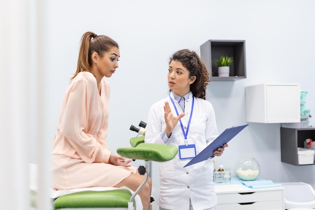 Um ginecologista é examinado por um paciente que está sentado em uma cadeira ginecológica Exame por um ginecologista Conceito de saúde feminina