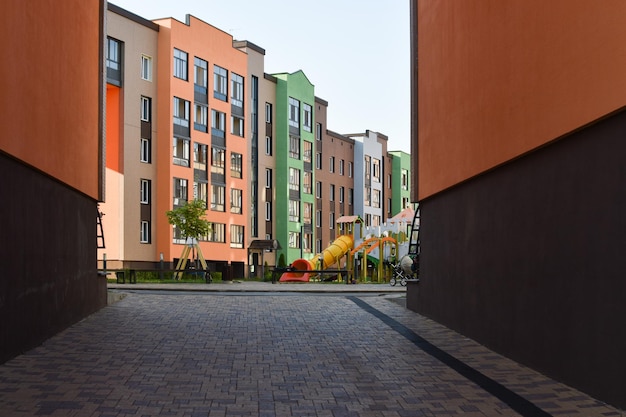 Um grande arco com acesso a um moderno parque infantil para crianças Um novo bairro residencial multiapartamento de casas europeias Abstração na cidade