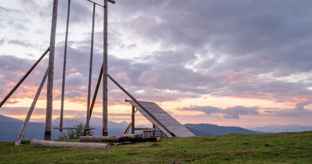 Foto um grande balanço de madeira no topo de uma montanha um deck de observação nas montanhas um amanhecer incrível nas montanhas dos cárpatos da ucrânia