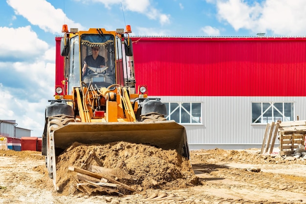 Um grande carregador frontal despeja areia em uma pilha em um canteiro de obras transporte de materiais a granel equipamento de construção transporte de carga a granel escavação