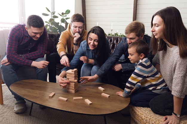 Um grande grupo de amigos joga jogos de tabuleiro, uma alegre companhia em casa. Foto de alta qualidade