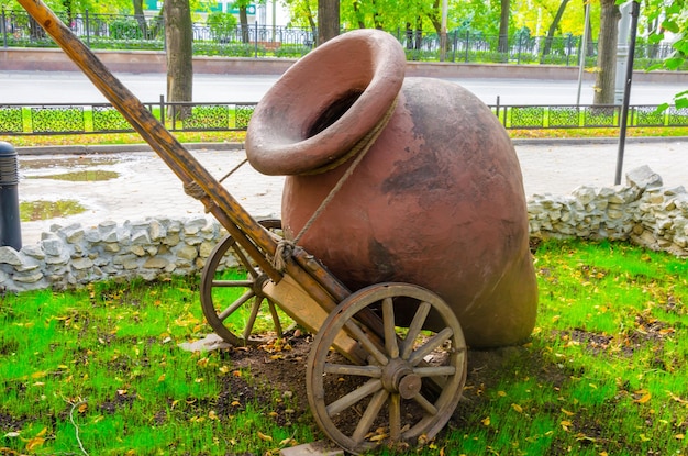 Um grande jarro de barro em um carrinho.