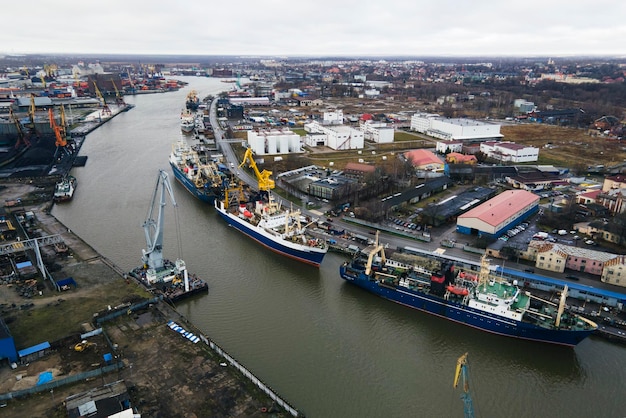 um grande navio azul e guindastes amarelos na água no porto de uma cidade industrial. Transporte de cargas por via marítima. conceito. vista de cima, vista aérea