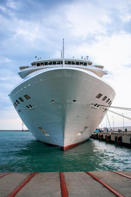 Um grande navio de cruzeiro branco está ancorado no porto um navio de passageiros espera turistas vista frontal