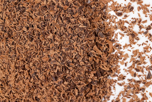 Um grande número de gotas de chocolate na superfície migalhas e pedaços de chocolate que são usados na culinária e na preparação de sobremesas