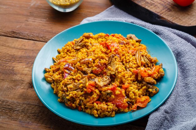 Um grande prato de bulgur com legumes e cogumelos em uma mesa em um guardanapo