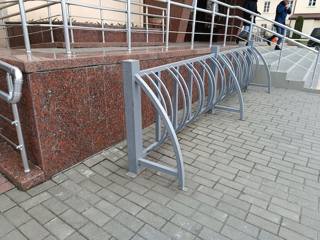 Um grande suporte de metal para bicicletas está instalado em uma parede de tijolos.