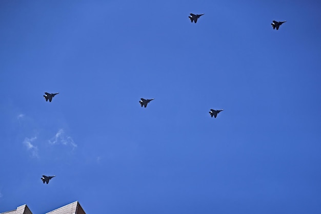 Foto um grupo da força aérea do exército russo mostra acrobacias aéreas no céu azul desfile de aeronaves militares sobre o