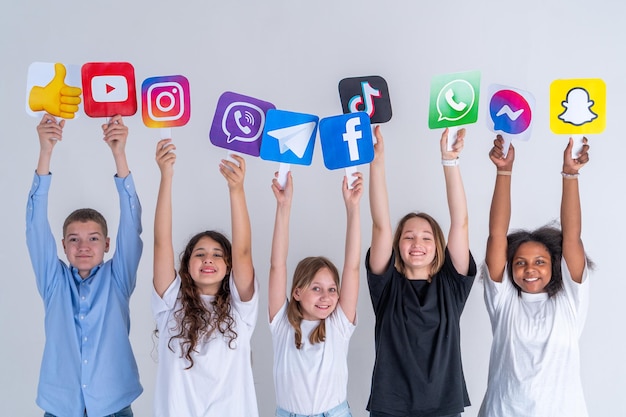 Um grupo de adolescentes está segurando ícones de mídia social do Instagram, Youtube, Tiktok, Whatsapp nas mãos e sorrindo. Turquia, Istambul, 29 de maio de 2022.