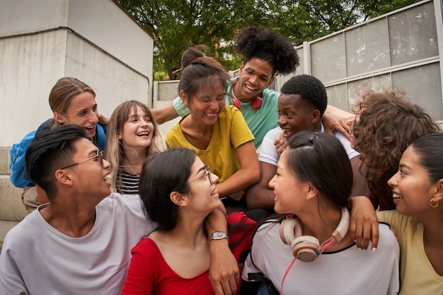 Foto um grupo de alunos se divertindo fora de felizes colegas de classe na escola de volta à escola juntos a ...