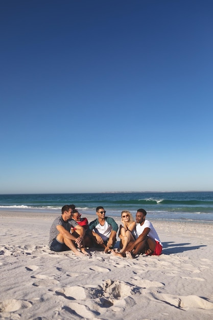 Foto um grupo de amigos a divertir-se juntos na praia.