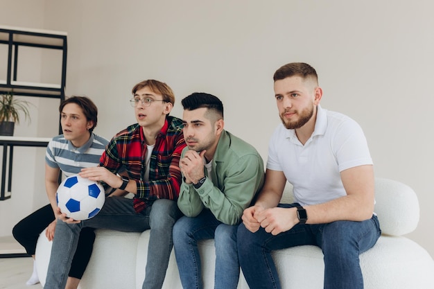 Um grupo de amigos assistindo a uma partida de futebol na TV Football Fans