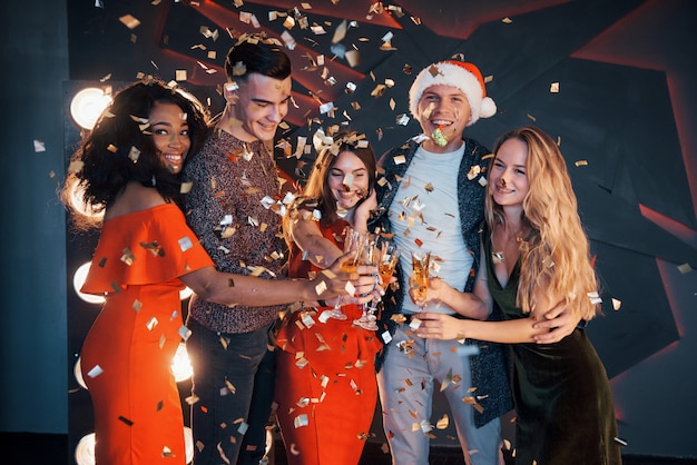 Um grupo de amigos posando e se divertindo com bonecos de neve e champanhe. Celebração de Ano Novo.