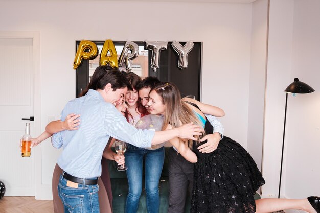 Um grupo de amigos reunidos fazendo uma festa e celebrando juntos em um apartamento.
