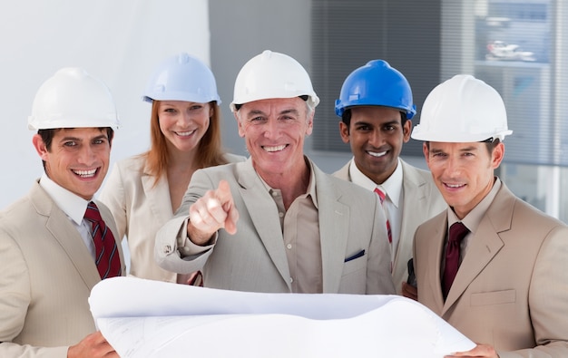 Foto um grupo de arquitetos sorridentes estudando planos