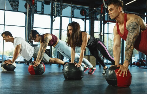 Um grupo de atletas musculosos fazendo exercícios na academia Ginástica, treinamento, fitness, treino