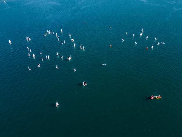 um grupo de barcos estão flutuando na água com um veleiro na água