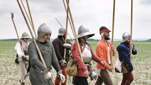 Um grupo de cavaleiros medievais com lanças se preparando para o ataque.