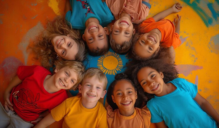 Foto um grupo de crianças vestindo camisas de cores brilhantes com o sol sobre elas