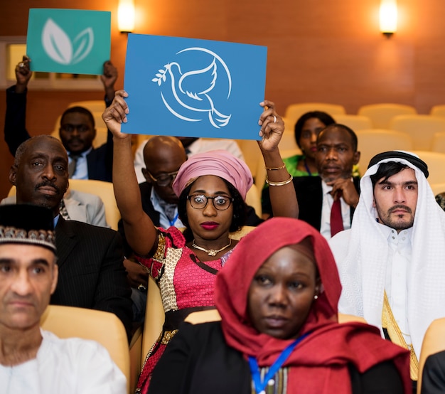 Um grupo de delegados internacionais está mostrando símbolo de paz e meio ambiente