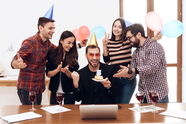 Um grupo de empregados de escritório celebra a empresa do dia.