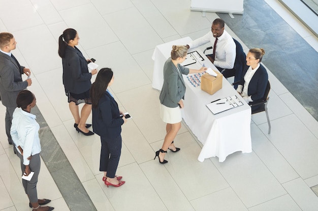 Um grupo de empresários diversos a fazer fila para votar.